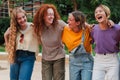 Group of joyful college student women in casual clothing, laughing and enjoying a nice weekend. Real cool girls walking Royalty Free Stock Photo