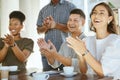 Group of joyful diverse businesspeople clapping hands in support during a meeting together at work. Happy business