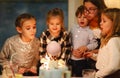 Group of joyful little kids celebrating birthday party and blowing candles on cake Royalty Free Stock Photo