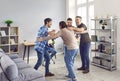 Group of joyful male friends having fun, drinking beer, and hugging at a party at home Royalty Free Stock Photo