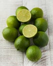 A group of juicy ripe limes on a white wooden background. Whole and cut in half limes. Royalty Free Stock Photo