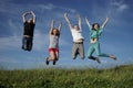 Group of jumping people on grean meadow