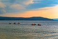 Group of kayakers paddling in a lake at a picturesque sunset