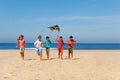 Group of kid run with colorful kite on a beach Royalty Free Stock Photo