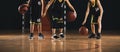 Group of kids bouncing basketball balls on a wooden court. Children on basketball training class