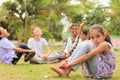 Group of kids bulling girl at park during summer camp - Little girl looking camera, sitting lonely while friends playingand having Royalty Free Stock Photo