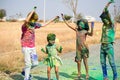 Group of Kids with colors applied dancing during holi festival celebration - Concept of joy and cheerful celebration Royalty Free Stock Photo