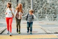 Group of 3 kids crossing the road, walking back to school Royalty Free Stock Photo