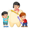 The group of kids are holding toothbrush and brushing a big tooth