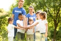 Group of kids joining hands with volunteers Royalty Free Stock Photo