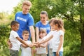 Group of kids joining hands with volunteers Royalty Free Stock Photo