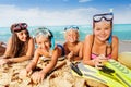 Group of kids lay on the beach in snorkeling masks