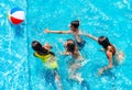 Group of kids play action game with ball in pool Royalty Free Stock Photo