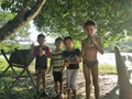 A group of kids posing for camera under a tree on December 8th, 2019 at Kota Belud, Sabah, Malaysia.