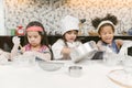 Group of kids are preparing the bakery in the kitchen .Children learning to cooking cookies.