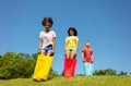 Group of kids race in bags downhill on the lawn Royalty Free Stock Photo