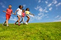 Group of kids run on the grass field holding hands Royalty Free Stock Photo