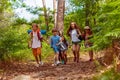 Group of kids running in the forest holding hands