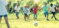 Group of kids are running and playing football in the park Royalty Free Stock Photo