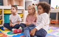 Group of kids sitting on floor with relaxed expression at kindergarten Royalty Free Stock Photo