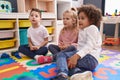 Group of kids sitting on floor with relaxed expression at kindergarten Royalty Free Stock Photo