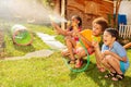 Kids hide and shoot with water guns in fun game Royalty Free Stock Photo