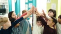 Group of kids students smiling confident with hands together raised up at classroom Royalty Free Stock Photo