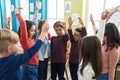 Group of kids students smiling confident with hands together raised up at classroom Royalty Free Stock Photo