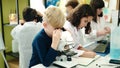 Group of kids students using microscope at laboratory classroom Royalty Free Stock Photo