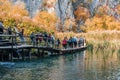 Group of kids walking on a wooden deck in Plitvice Lakes national park in autumn