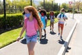 Group of kids wearing face masks walking on footpath Royalty Free Stock Photo