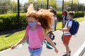 Group of kids wearing face masks walking on footpath Royalty Free Stock Photo