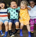 Group of kindergarten kids friends arm around sitting and smiling fun Royalty Free Stock Photo