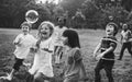 Group of kindergarten kids friends playing blowing bubbles fun