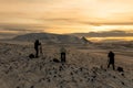 Group of landscape photographers making photos of cloudy sunset in winter Iceland