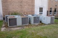 Group of large air conditioner compressors outside commerical building