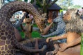 Group of large wooden handcrafted sculptures of lion, giraffe, zebra and leopard in the garden of Cultural Heritage store in