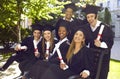 Group of laughing multicultural people in graduation gowns and caps graduate universuty.