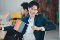 Group of LGBTQ businessmen with a rainbow flag in hand are having fun with their colleagues inside the office. The concept of