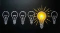 Group of light bulbs with one shining brightly representing innovation, creativity, and bright ideas on black background Royalty Free Stock Photo