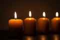 Group of lit candles in a row burning in the darkness Royalty Free Stock Photo