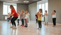 Group of little boys and girls dancing while having choreography class in the dance studio. Female dance teacher and