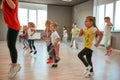 Studying modern dance. Group of little boys and girls dancing while having choreography class in the dance studio