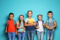 Group of little children with backpacks school supplies on color background Royalty Free Stock Photo