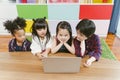 Group of little children diversity watching film together on laptop. Kids playing with laptop computer at home. Royalty Free Stock Photo