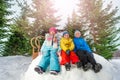 Group of little children sit on snow wall in park Royalty Free Stock Photo