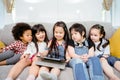 Group of little children watching film movie cartoon together on digital tablet. Kids playing with tablet with friends at home.