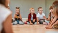Little dancers. A group of little cute girls and boys in casual clothes talking to each other while sitting in circle Royalty Free Stock Photo