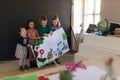 Group of little girls holding a picture they painted during creative art and craft class at school