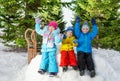 Group of little kids sit on snow wall in park Royalty Free Stock Photo